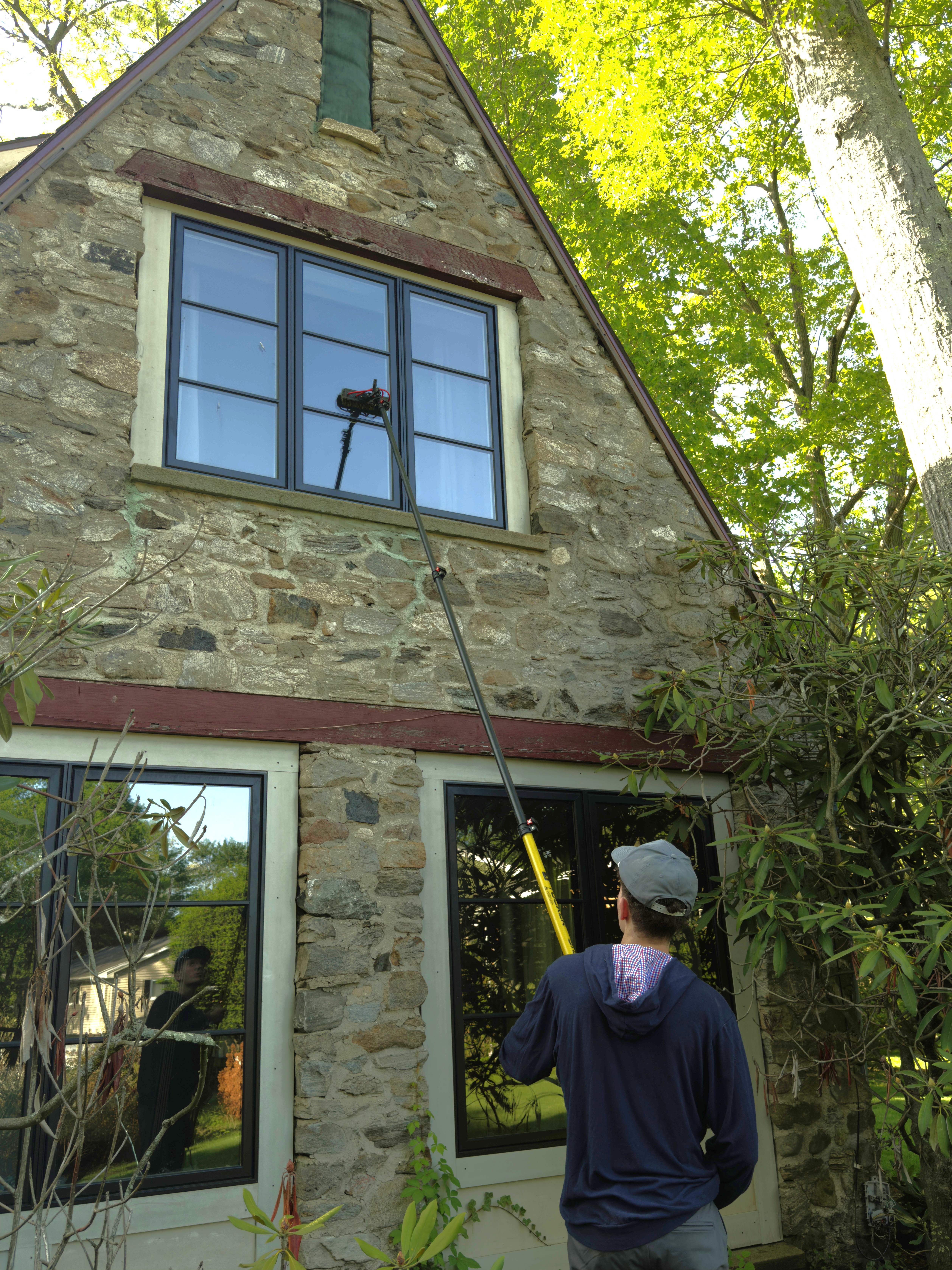 A staff member cleans a bluestone patio at the front of a customer's home.