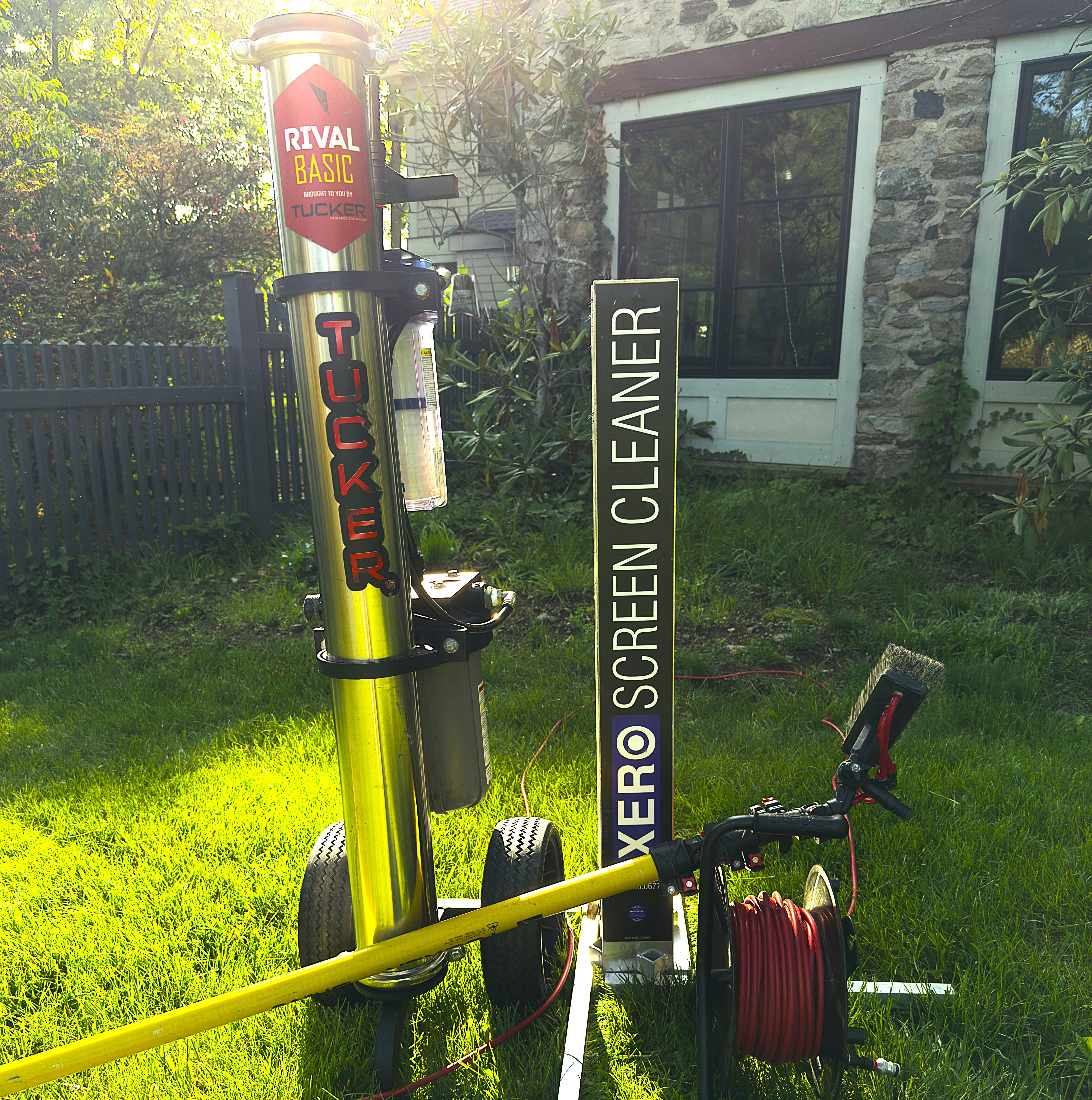 A pressure washing trailer with water pump, hose, large tank, hose reels, softwash system, and hotwater pressure washer.