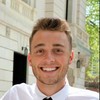 A satisfied customer in a white shirt and black tie smiling, representing a positive review for our pressure washing service on our website.